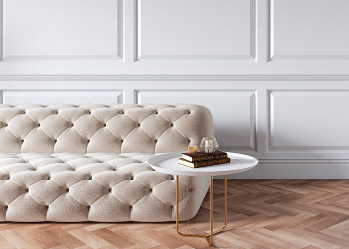 Un sofá color crema con una mesita